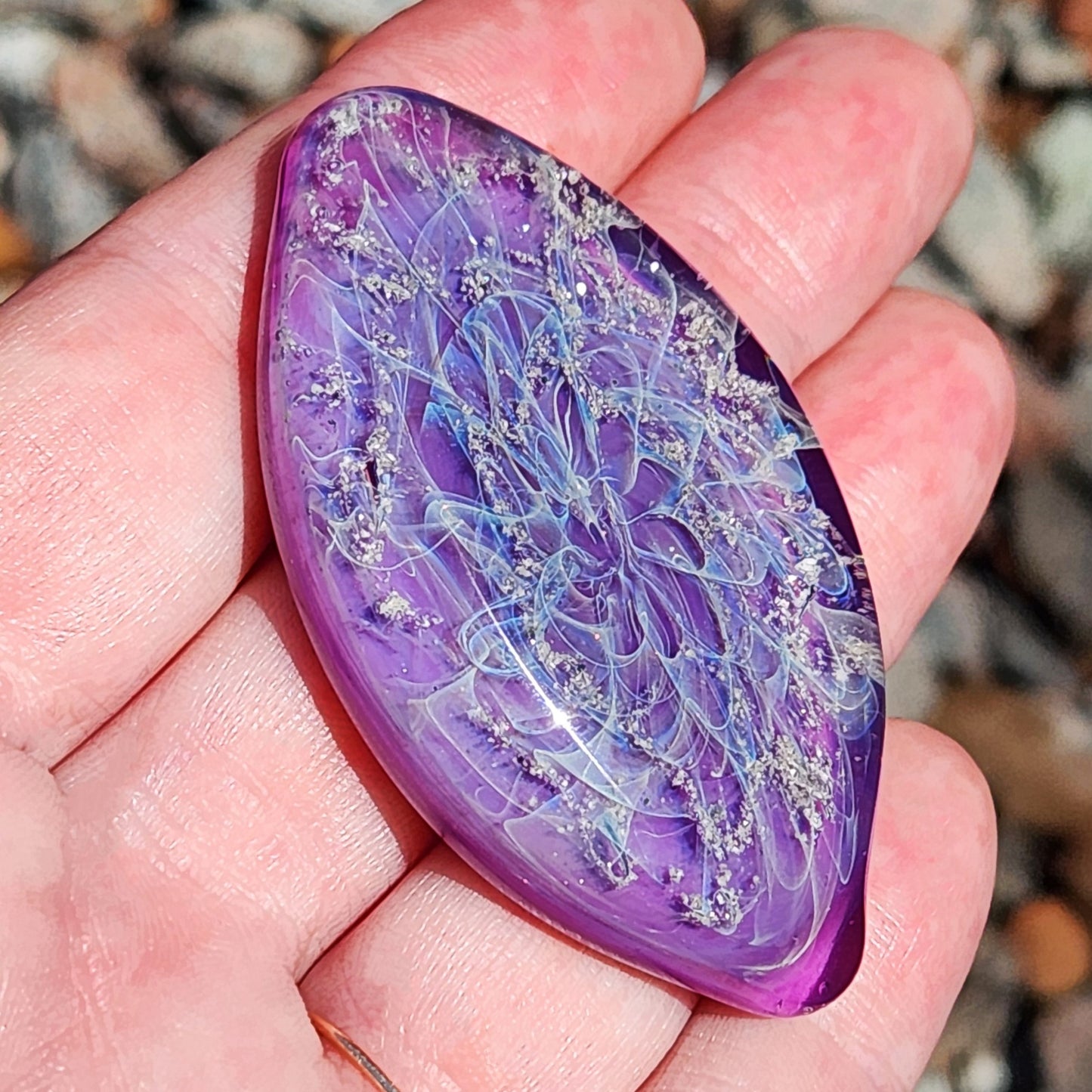 Galaxy Cremation Touchstone | Memorial Glass Keepsake with Ashes in purple and blue hues, featuring a swirling galaxy design held in hand.