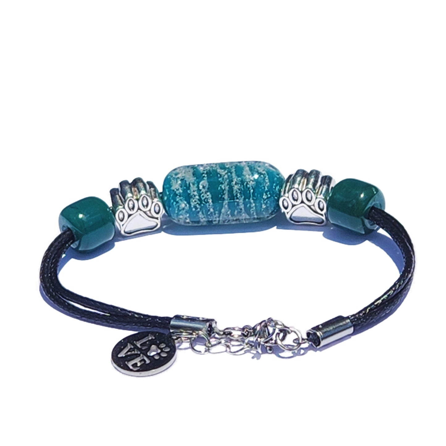 Paw Print Cremation Bracelet featuring ash-infused blue glass bead, silver paw charms, and black adjustable cord. Handmade pet memorial jewelry.