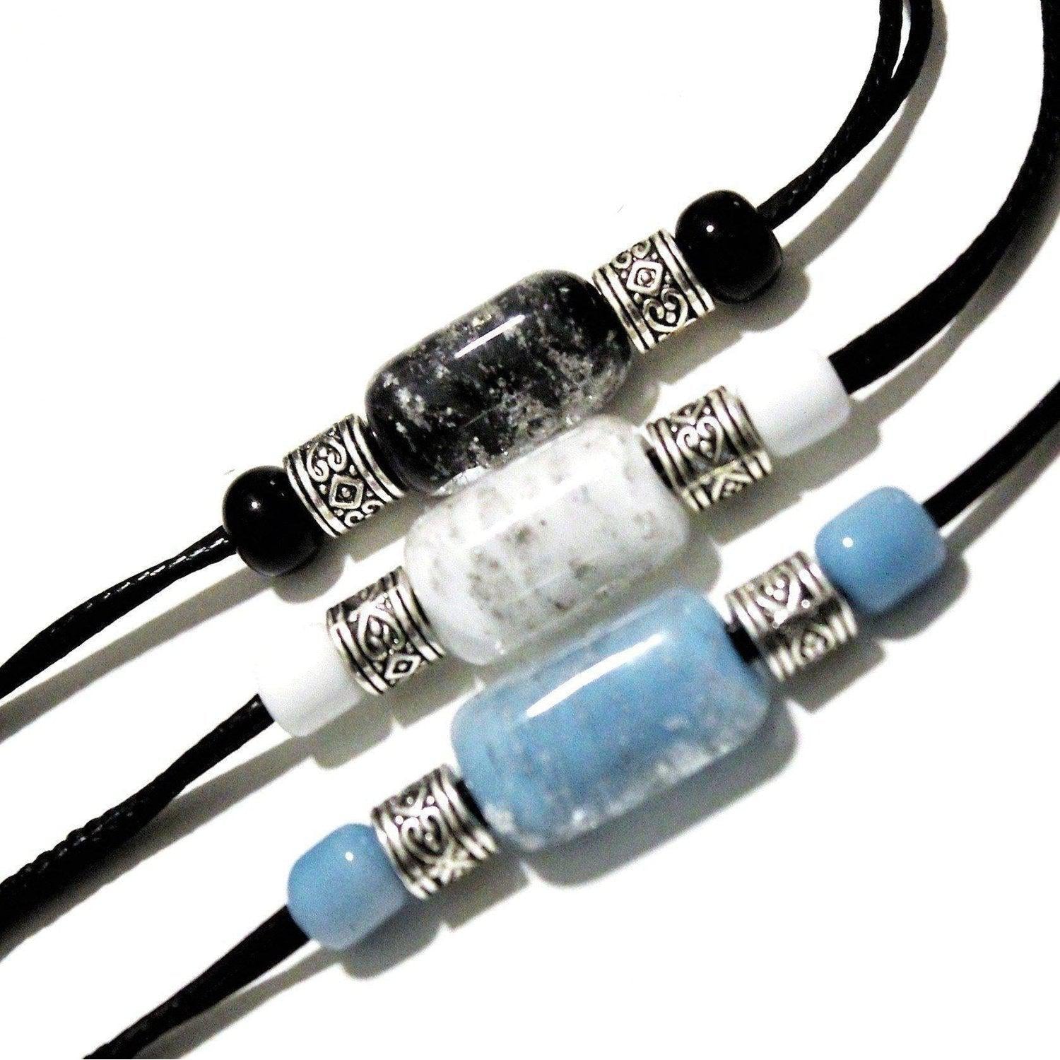 Bracelet with ashes featuring black, white, and blue cremation beads on black cords with silver accents. Handmade memorial jewelry for daily remembrance.