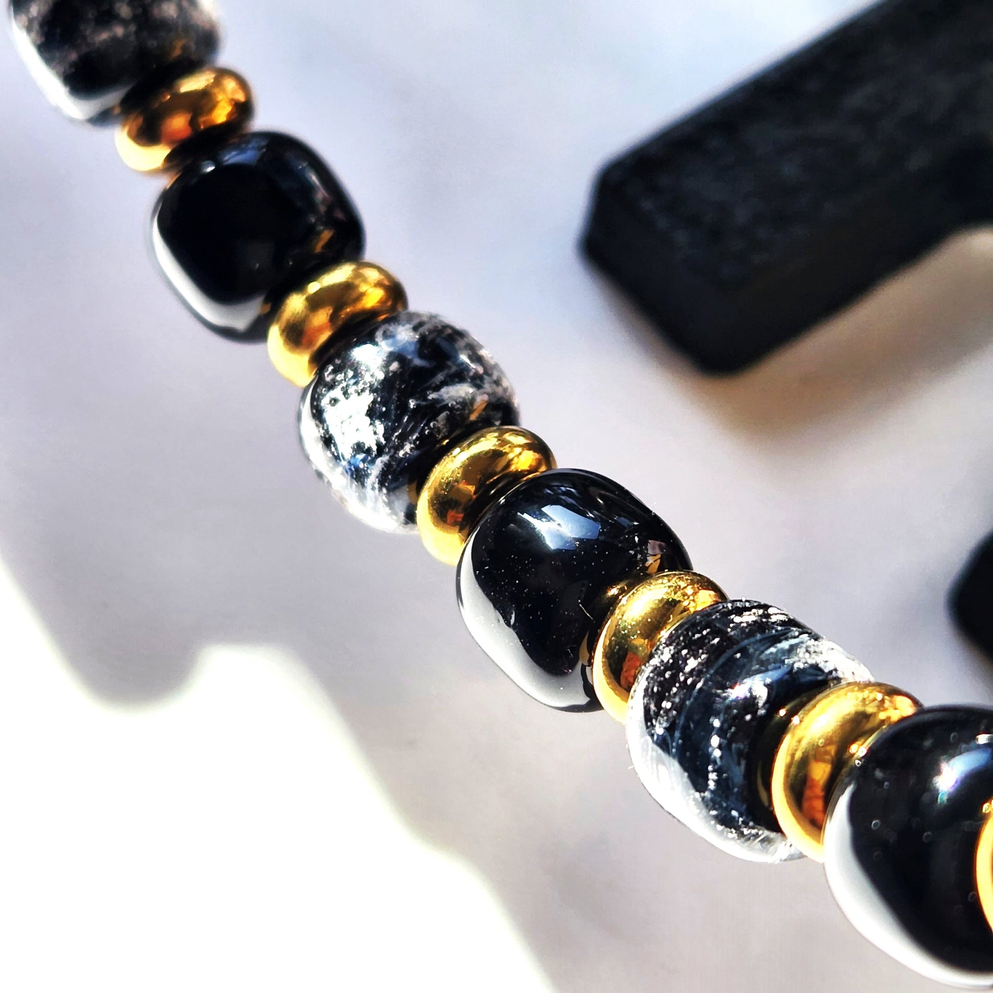 Black Memorial Bracelet for Men and Women featuring handmade ash-infused glass beads with gold spacers. A unique cremation bracelet from the Eternal Collection.