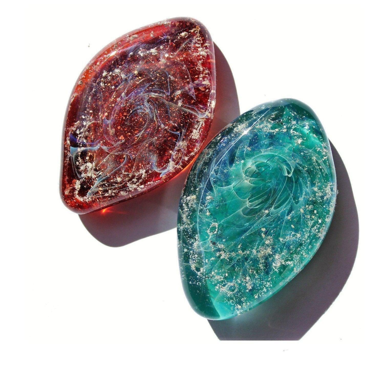Galaxy Cremation Touchstone in red and turquoise with ashes infused in glass. Memorial glass keepsake for honoring loved ones, durable and waterproof.