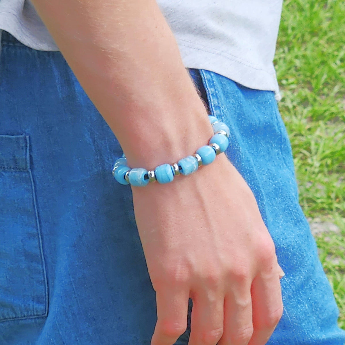 Sky Blue Cremation Bracelet worn on wrist, highlighting silver accents and ash-infused beads for a personal memorial tribute.