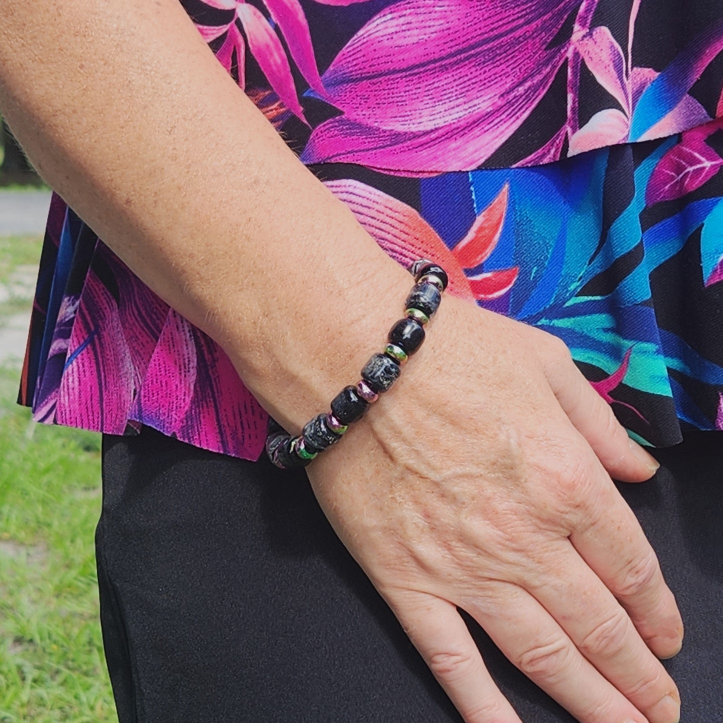 Black Memorial Bracelet from the Eternal Collection, featuring ash-infused glass beads and stainless steel, worn on wrist outdoors.