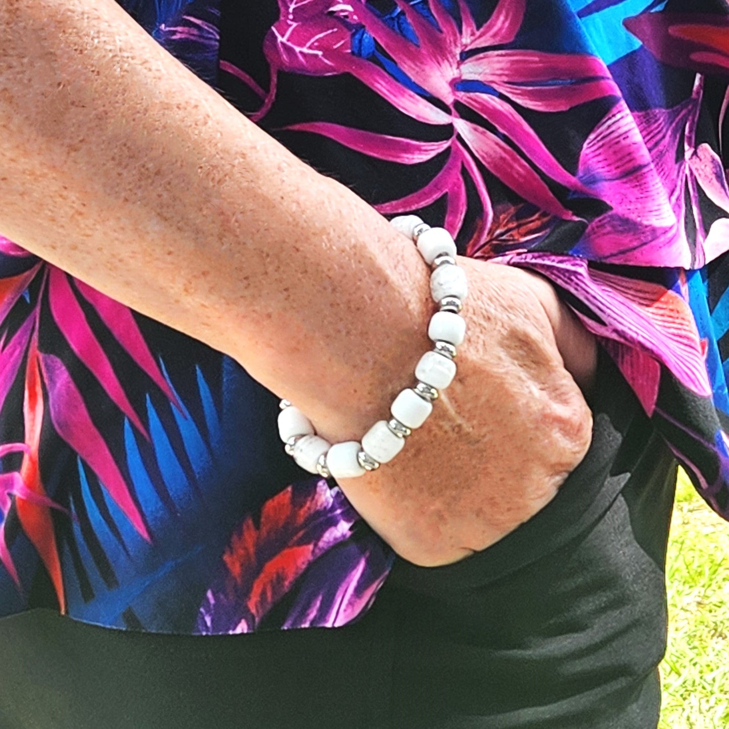 Custom Eternal Urn Bracelet with white cremation beads worn on wrist. Personalized ashes memorial jewelry gift for remembrance ceremonies.