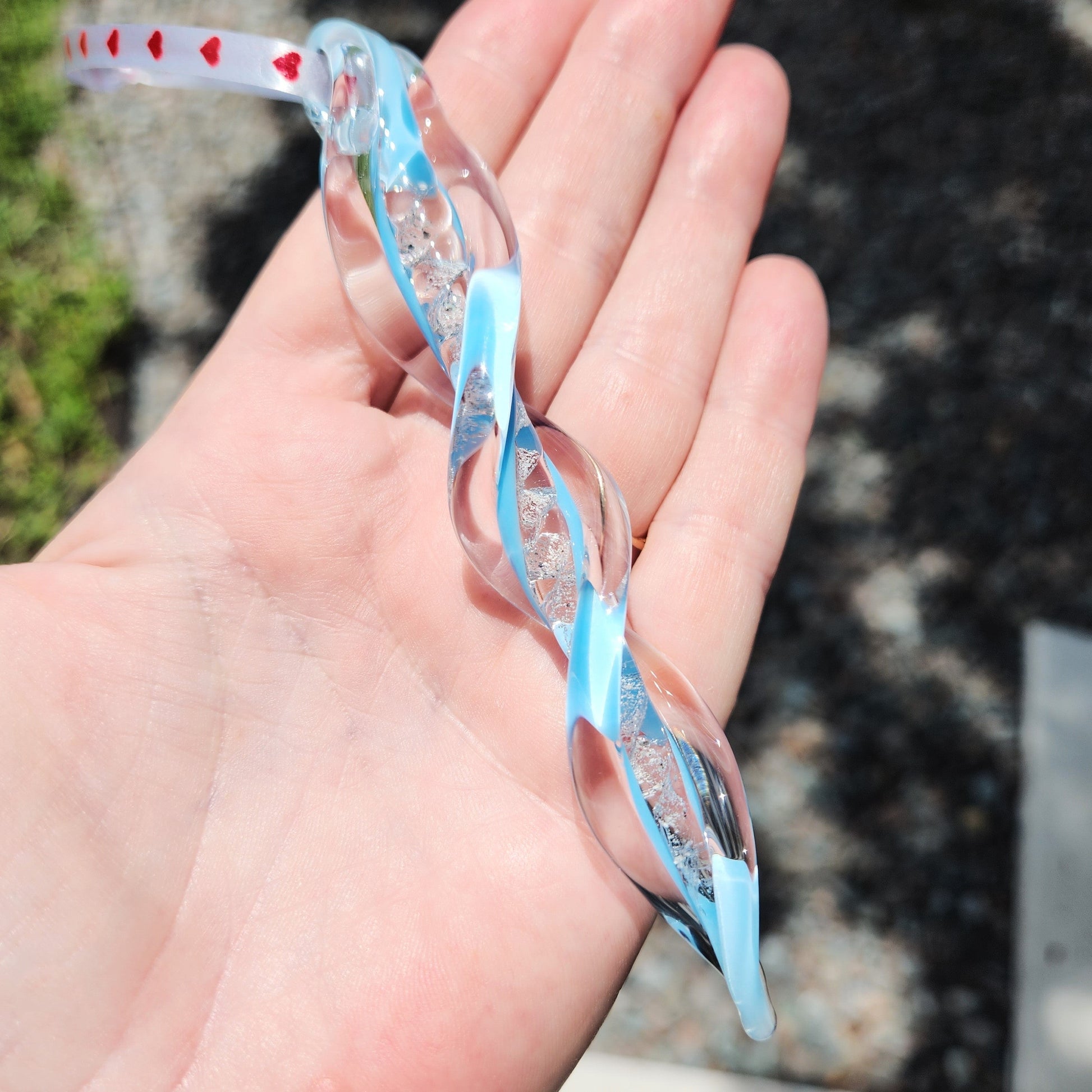 Frozen in Time Cremation Keepsake Suncatcher featuring a twisted glass icicle design with light blue accents and embedded ashes. A unique grief memorial ornament for honoring loved ones or pets.