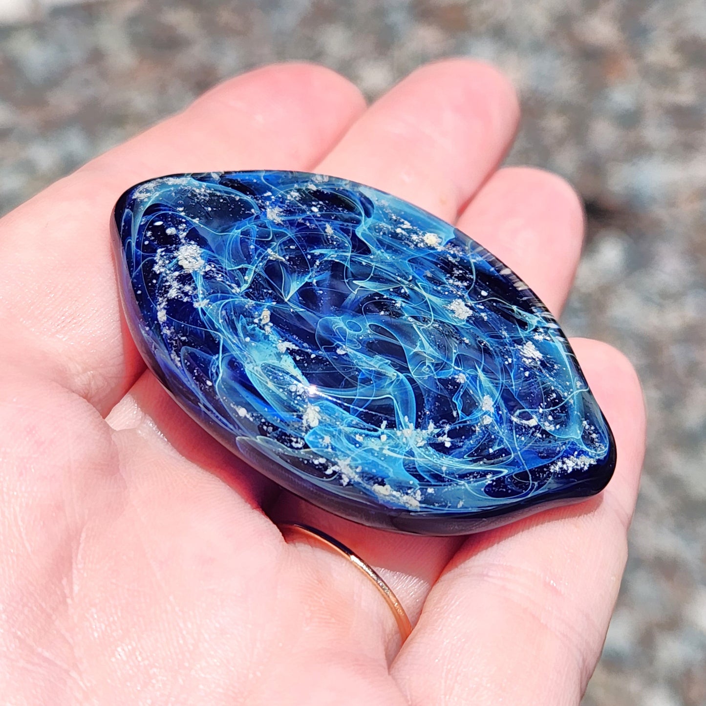 Galaxy Cremation Touchstone with swirling blue, turquoise, and white glass design, a memorial glass keepsake infused with ashes for remembrance.