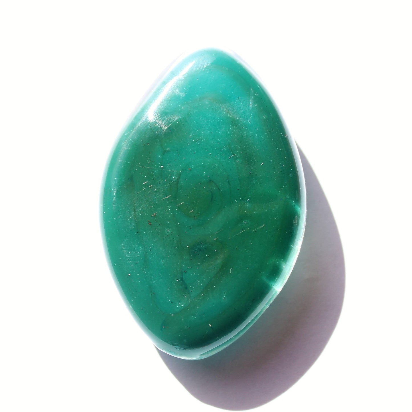 Galaxy Cremation Touchstone in turquoise with swirling ash pattern, a handmade memorial glass keepsake for ashes. Durable and waterproof design.