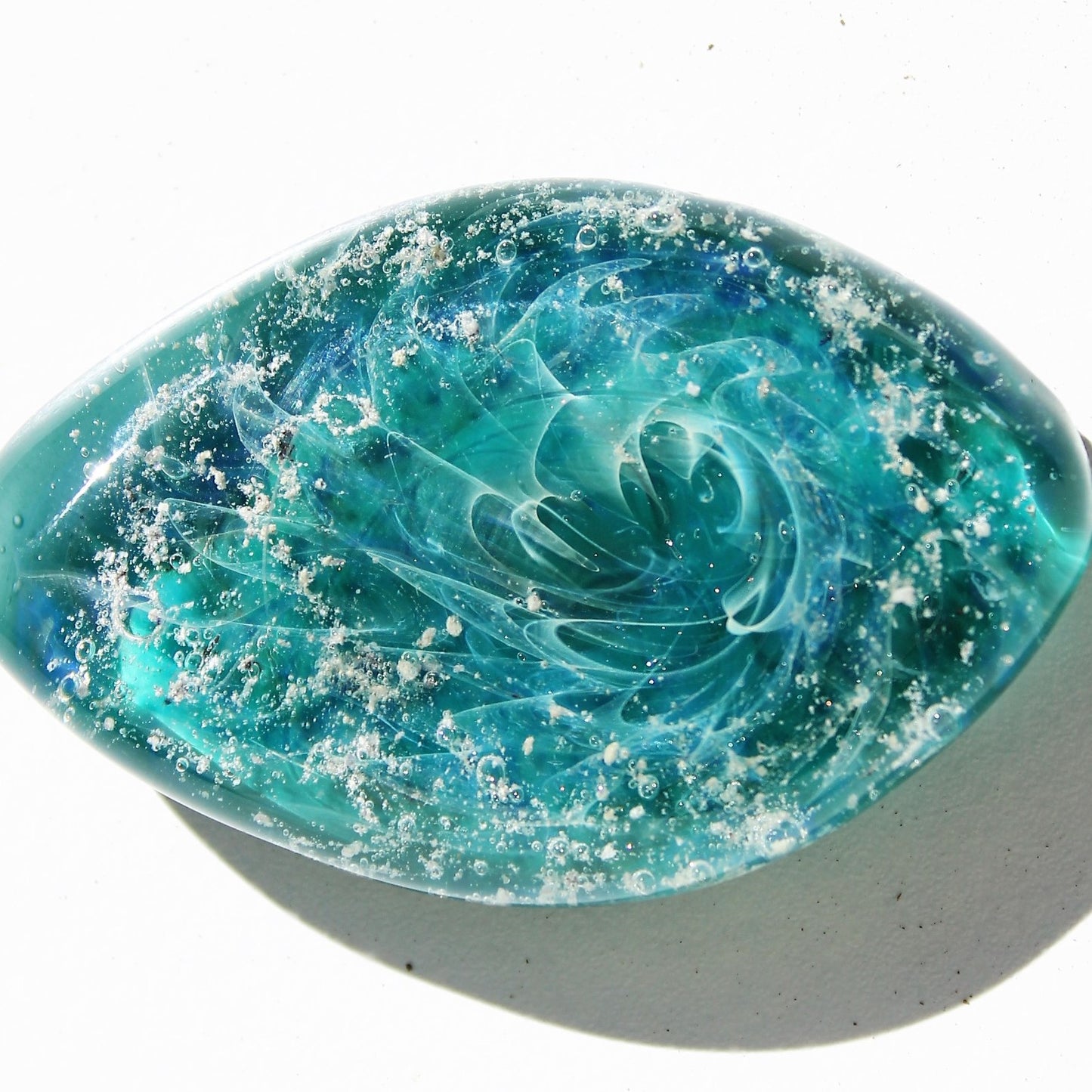 Galaxy Cremation Touchstone with swirling turquoise and blue glass design, infused with ashes. A unique memorial glass keepsake for remembrance.