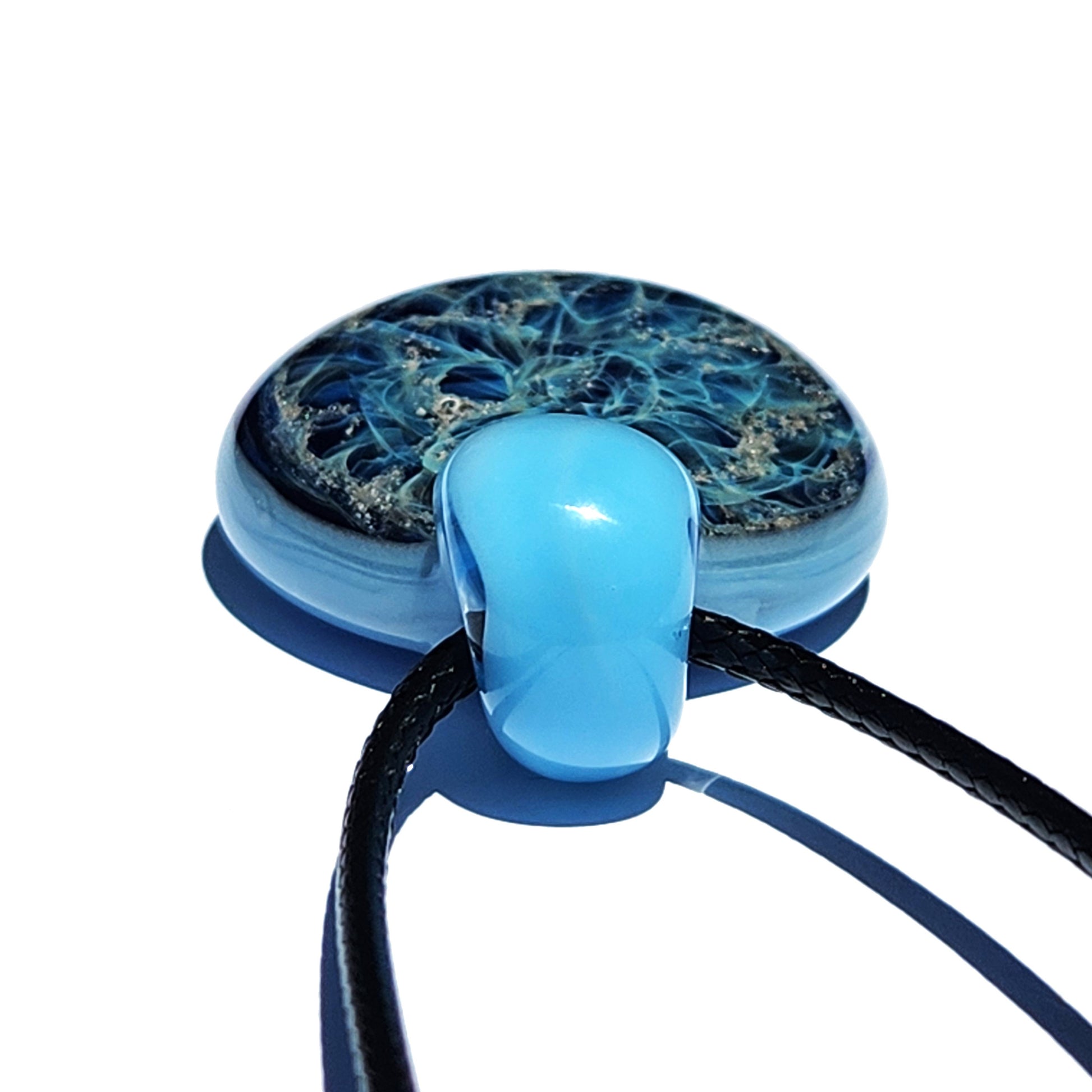 Galaxy Cremation Pendant – Handmade Ashes Memorial Necklace featuring a round glass design with swirling blue and silver patterns. Includes a durable black cord for wearing.