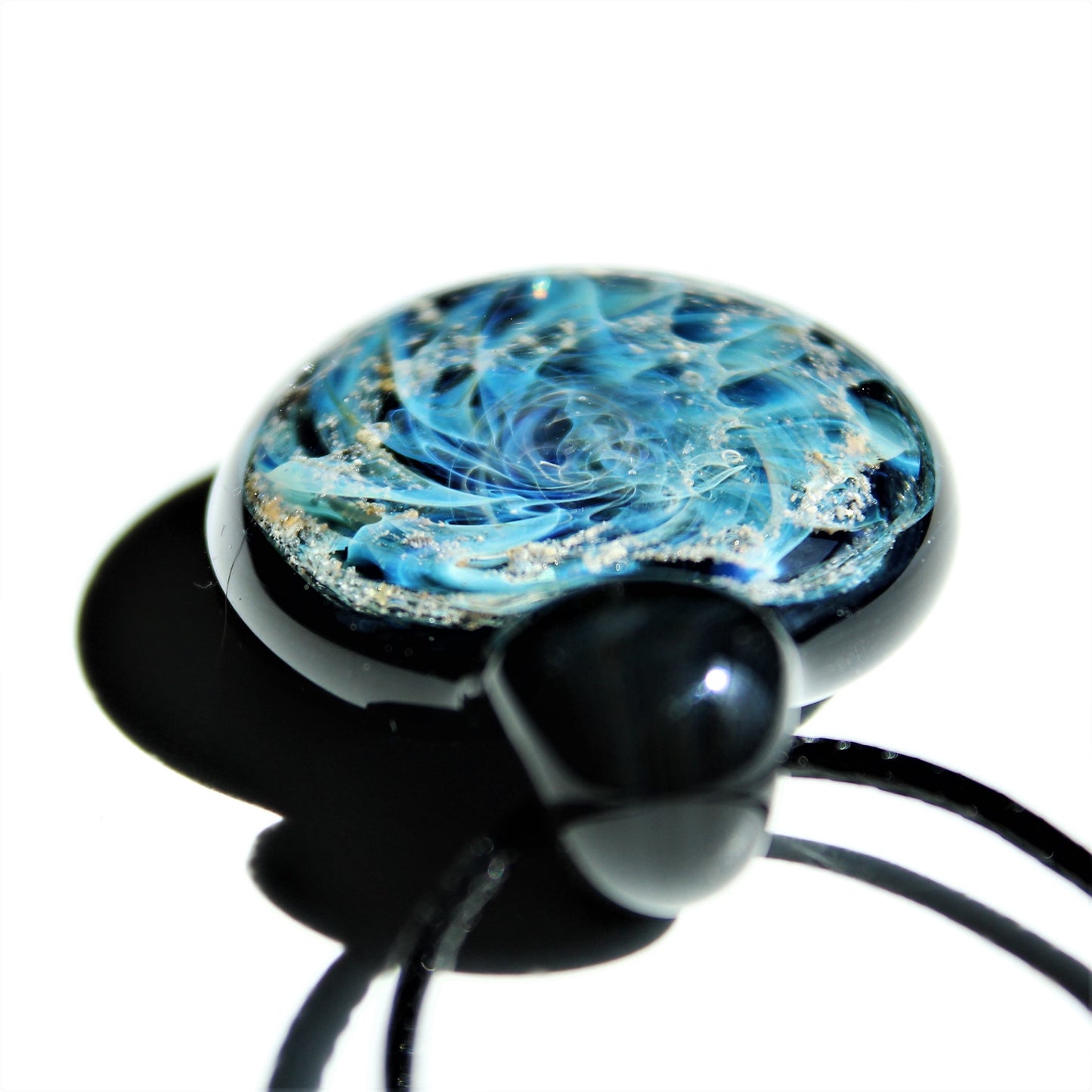 Galaxy Cremation Pendant – Handmade Ashes Memorial Necklace featuring swirling blue and white glass with embedded ashes in a black teardrop setting.