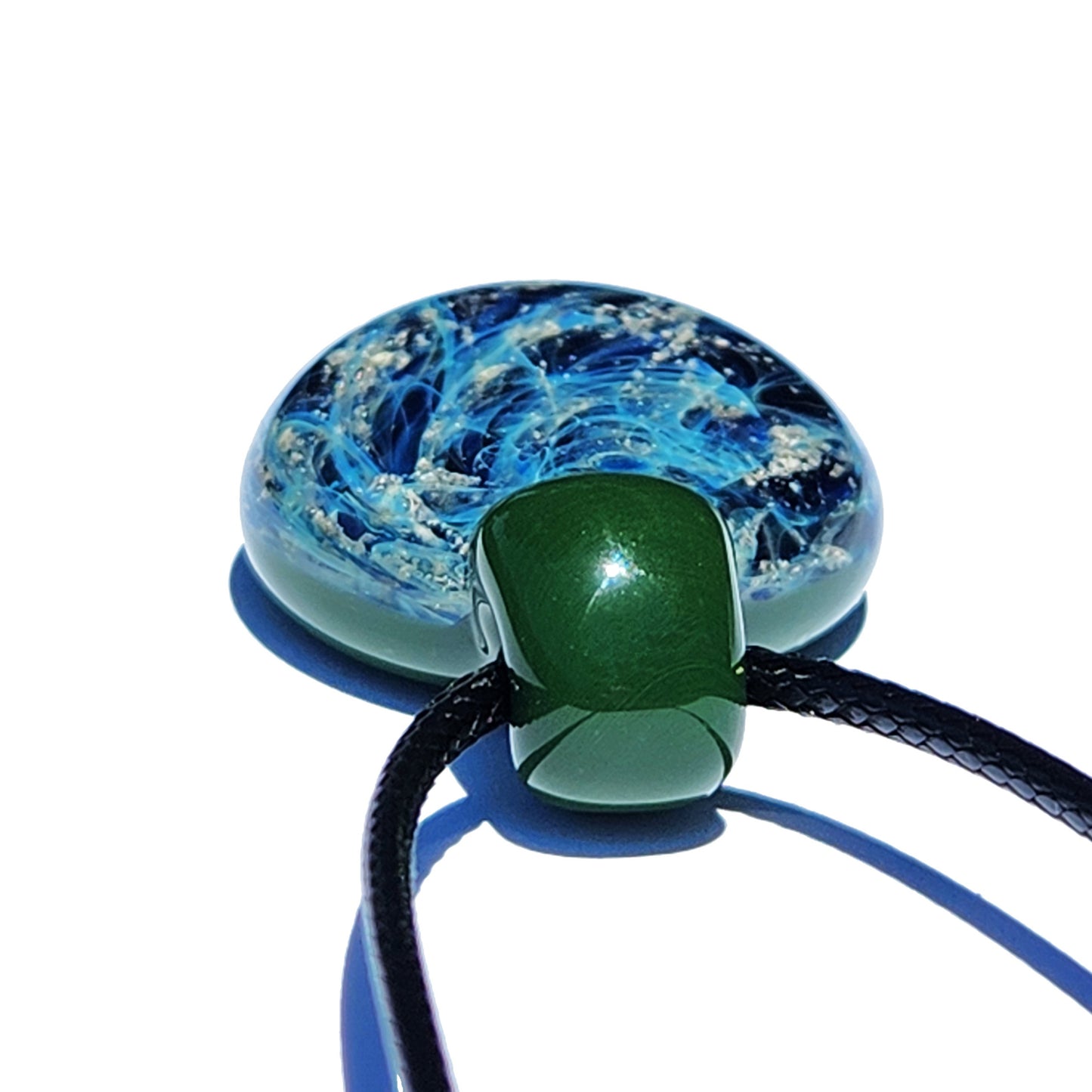 Galaxy Cremation Pendant – Handmade Ashes Memorial Necklace featuring swirling blue and black glass with silver ash inclusions and a green glass bail.