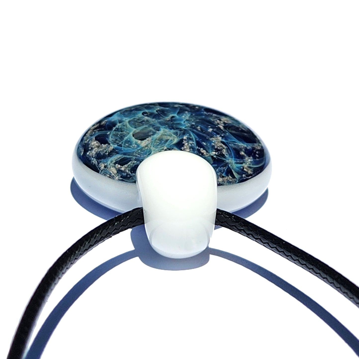 Galaxy Cremation Pendant – Handmade Ashes Memorial Necklace featuring a round glass design with swirling blue and silver patterns, set on a black cord. A unique and durable memorial urn keepsake for ashes.