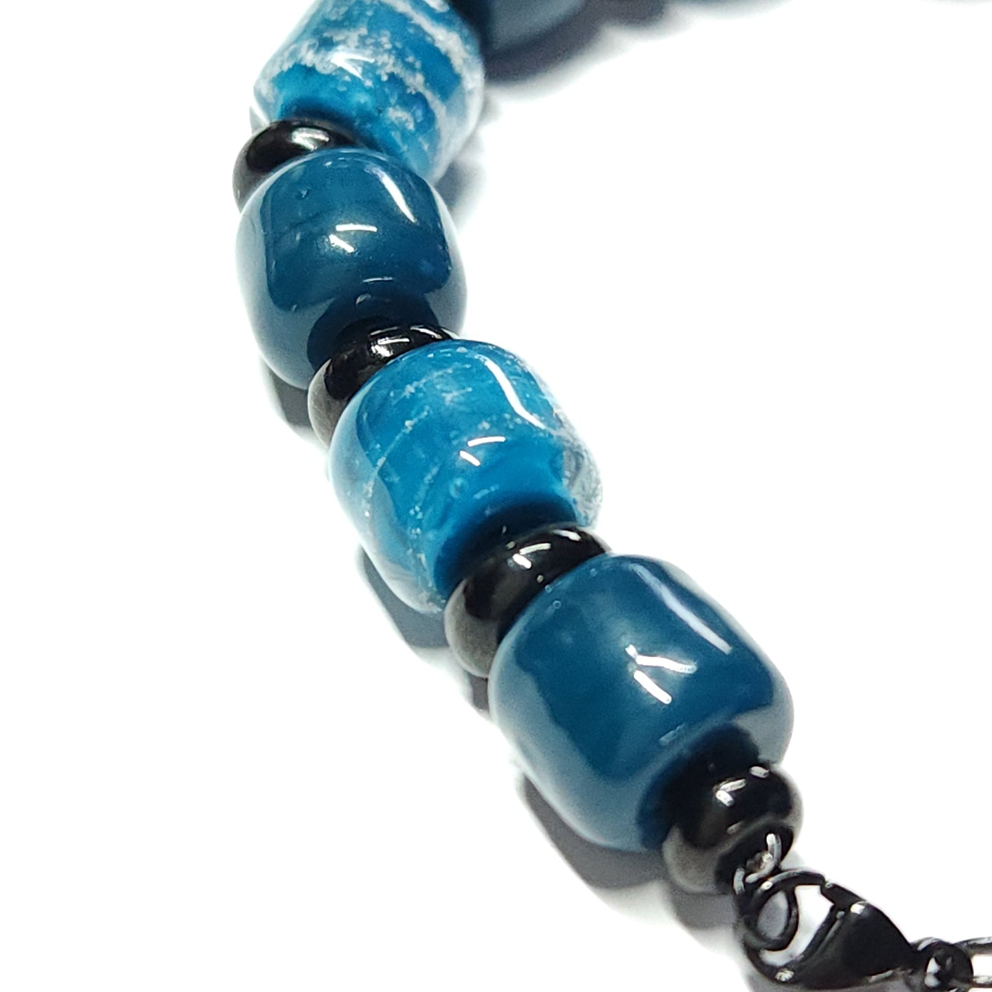 Ocean Blue Memorial Bracelet featuring ash-infused glass cremation beads and black steel spacers. Handmade tribute jewelry for memorial ceremonies.