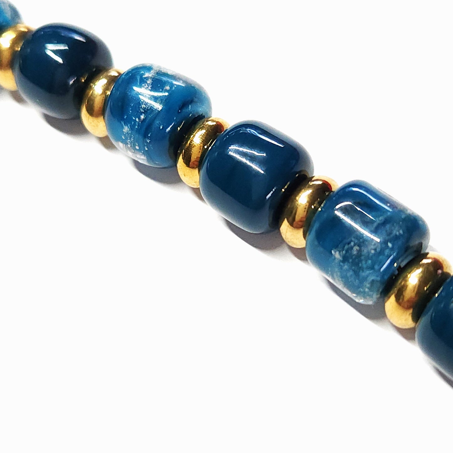 Ocean Blue Memorial Bracelet featuring ash-infused glass cremation beads with gold-tone steel spacers. Handmade tribute jewelry for memorial ceremonies.