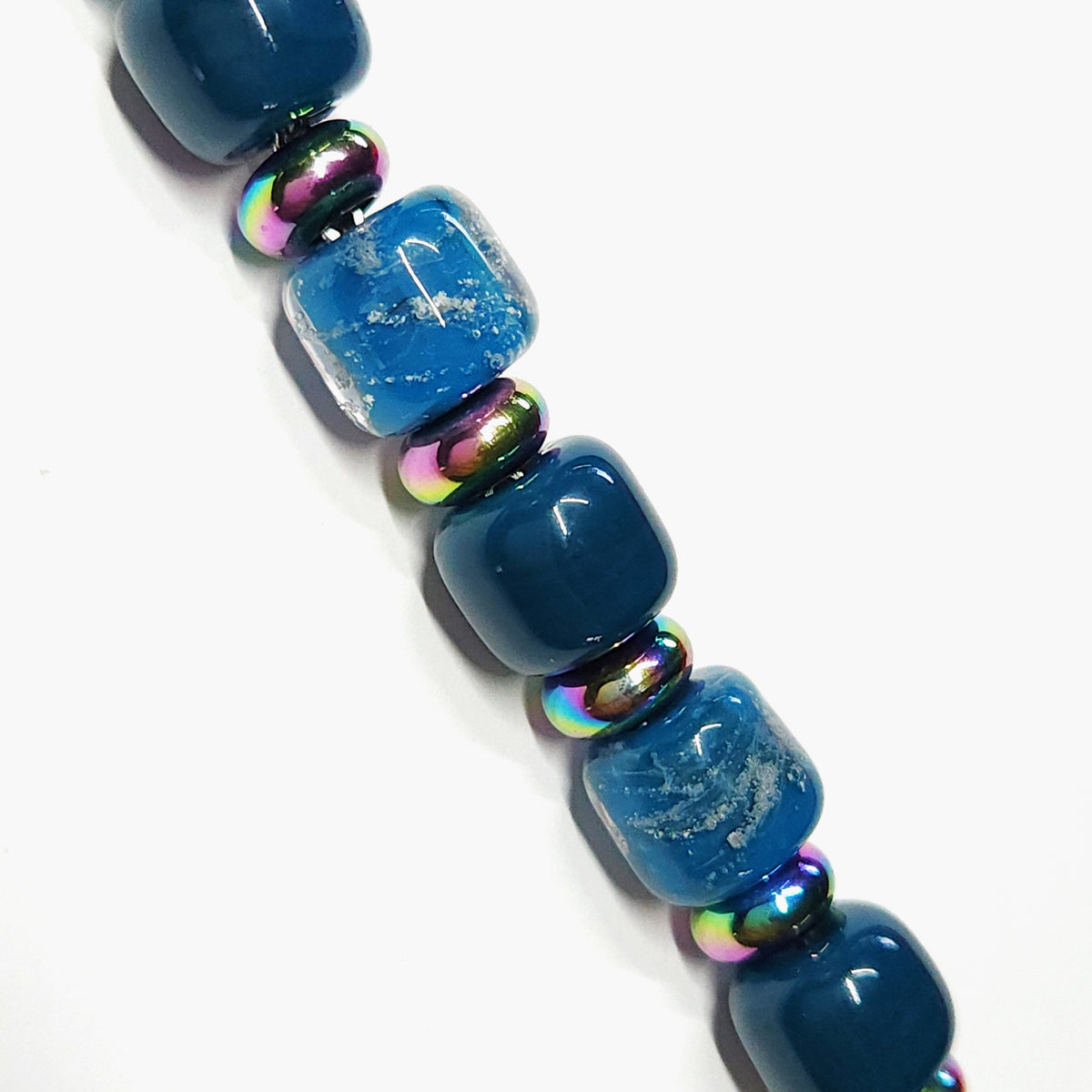 Ocean Blue Memorial Bracelet featuring ash-infused glass cremation beads with iridescent steel spacers. Handmade tribute jewelry for remembrance.