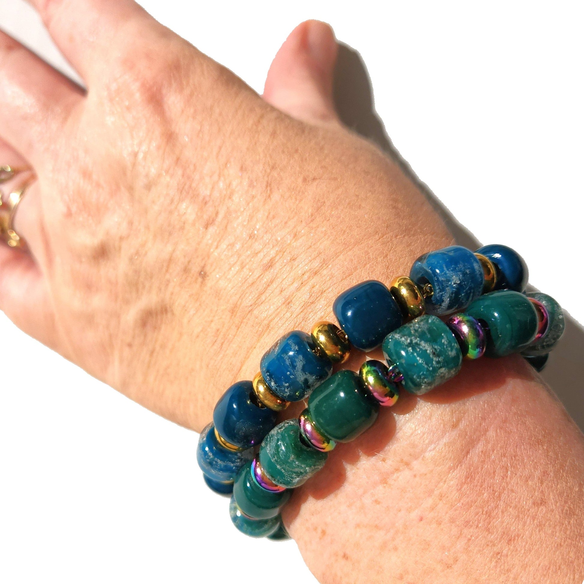 White Cremation Bracelet from the Eternal Collection shown worn on wrist, featuring ash-infused white beads with gold and colorful accents.