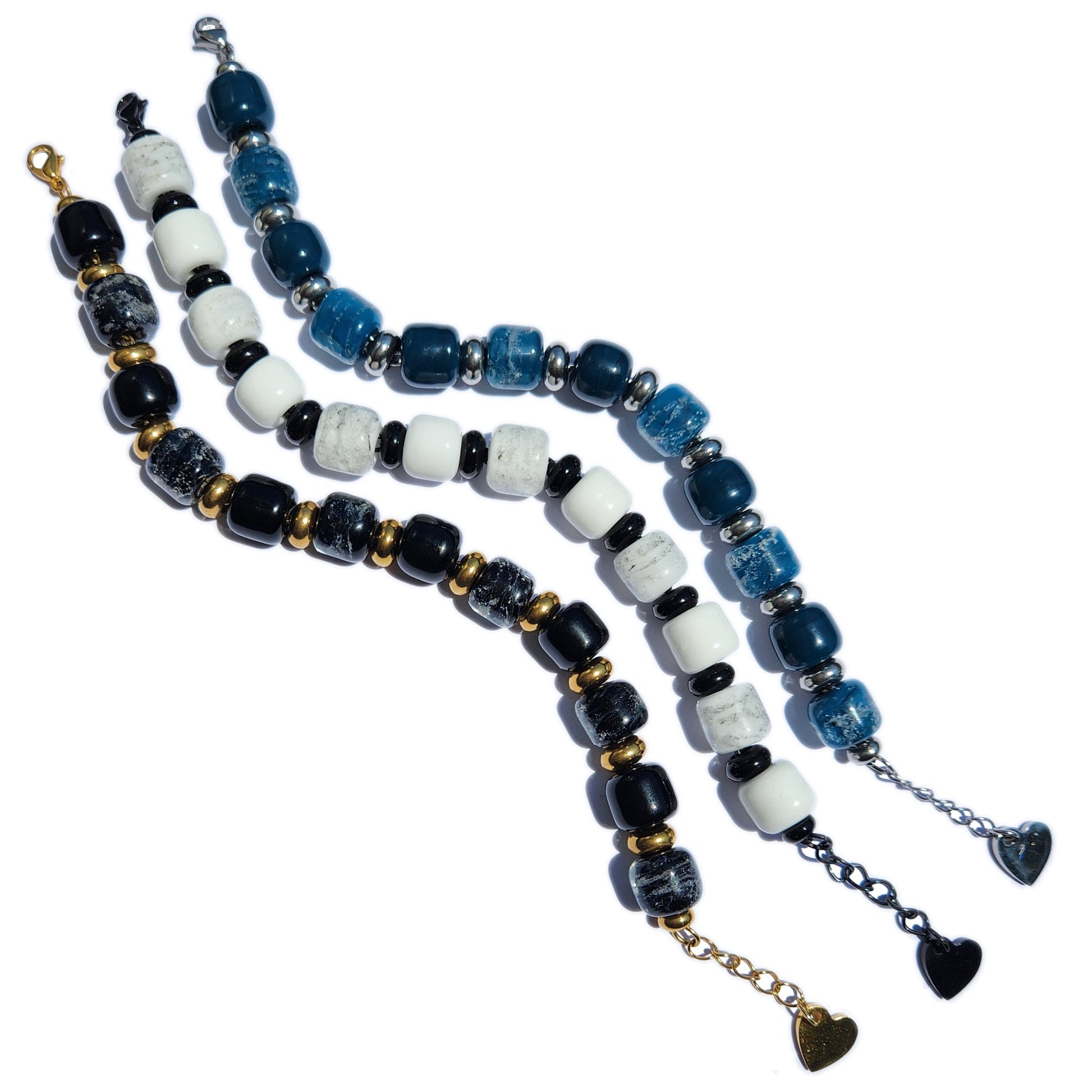 White Cremation Bracelet from the Eternal Collection featuring ash-infused beads in black, white, and blue tones with heart charm clasps.